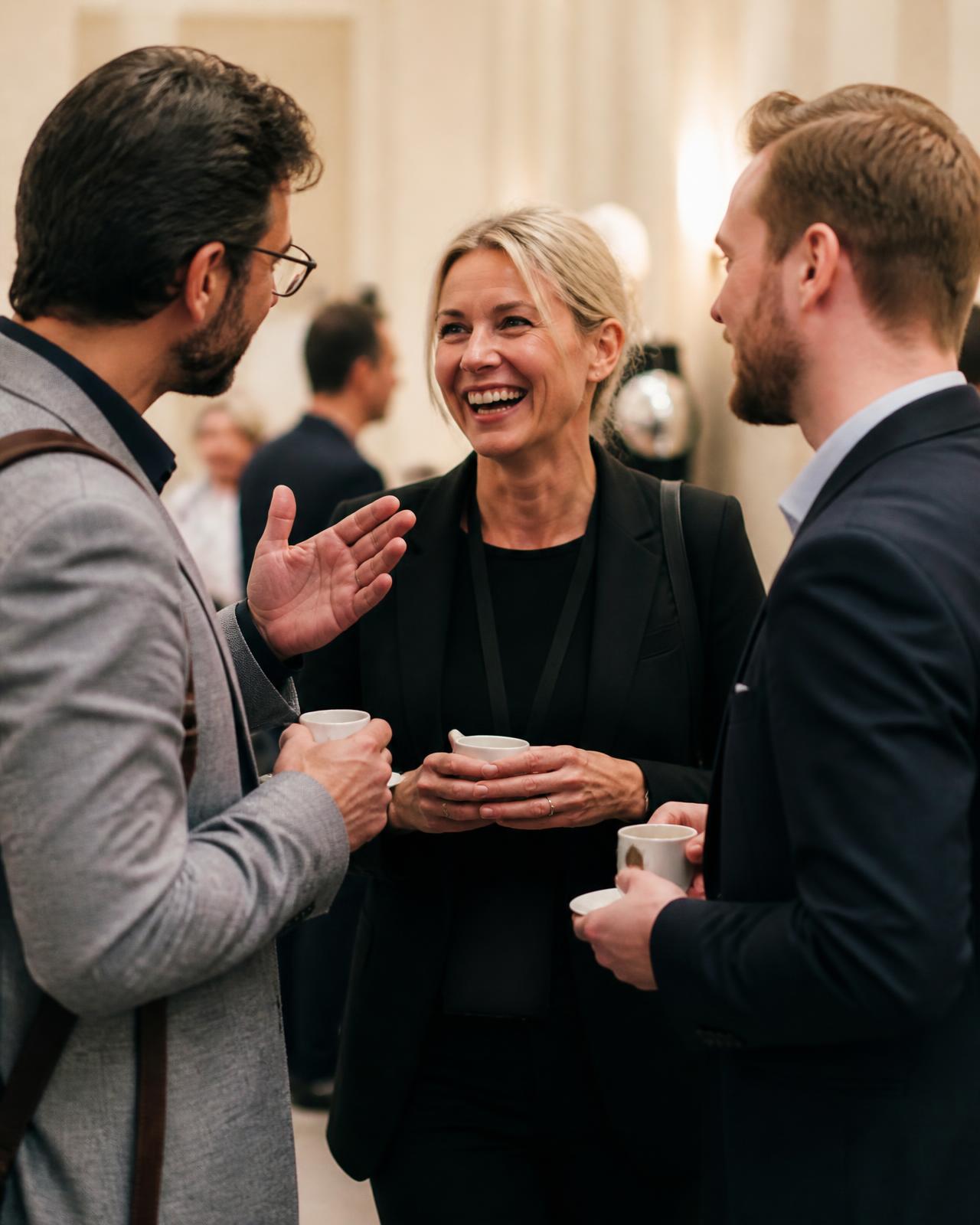 Tre professionisti dell'ospitalità conversano con un caffè in mano